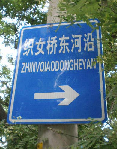 official directional sign reading '织女桥东河沿 ZHINVQIAODONGHEYAN' in white letters against a blue background