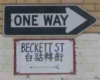 a one-way sign, beneath which is a hand-lettered sign reading BECKETT ST 白話轉街
