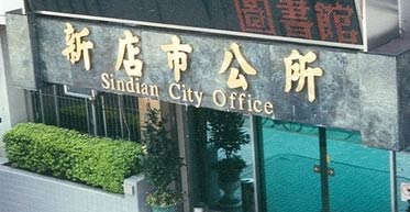 photo of the front of Xindian City Hall, across the street from the MRT station. The sign reads 'Sindian City Office'