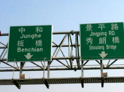 two large directional signs above a road across a bridge, as described in this post