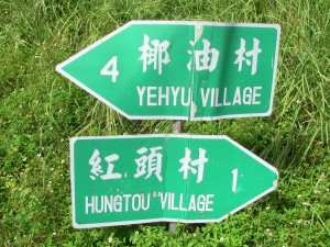 two directional signs reading '椰油村 YEHYU VILLAGE' and '紅頭村 HUNGTOU VILLAGE'