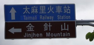 closeup of two signs reading Taimali Railway Station ?????? / Jinjhen Mountain ???