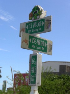 street signs reading ??? Rih Sheng Rd. / ??? Min Cyuan Rd.