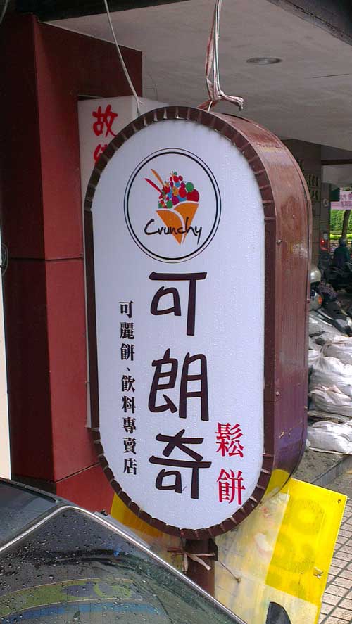 Sign advertising a store named 'Crunchy' in English and 'ke lang qi' (in Chinese characters) in Mandarin